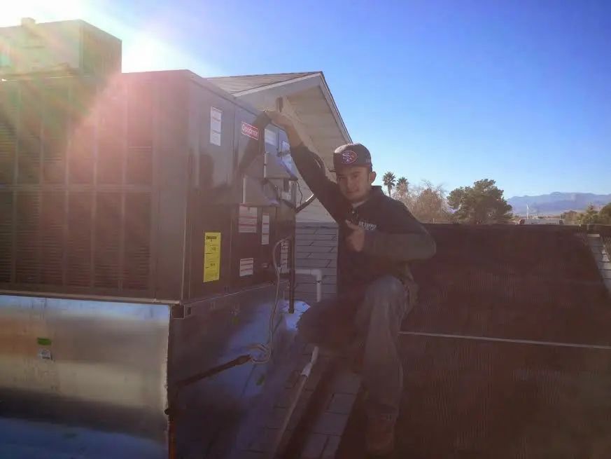 HVAC technician performing AC Tune-Up on a rooftop unit in Dillon